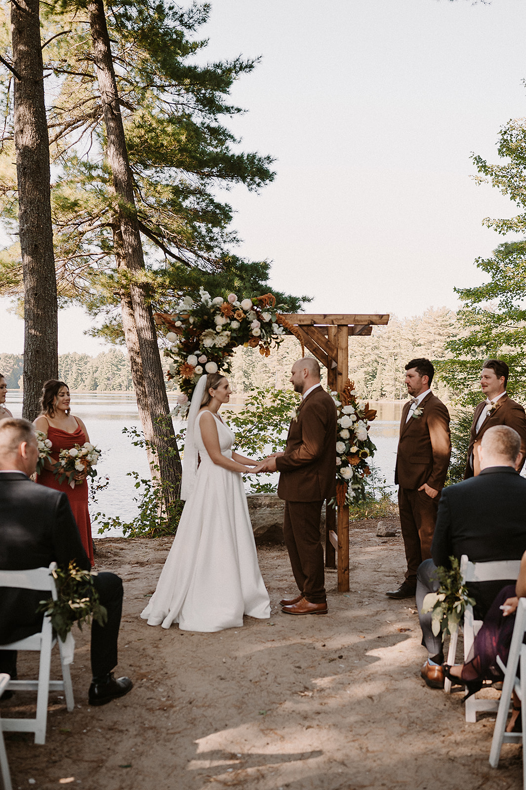 Couple holding hands during outdoor Muskoka wedding ceremony at Rocky Crest Resort